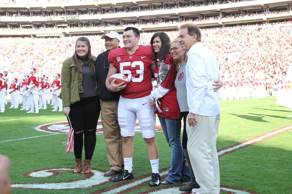 Ryan Parris and his family with Nick Saban being recognized on Senior Day on the field before the Auburn game.