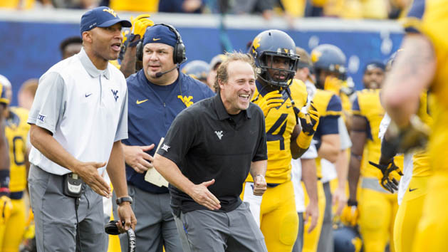 Sep 26, 2015; Morgantown, WV, USA; West Virginia Mountaineers head coach Dana Holgorsen celebrates with his players after scoring a touchdown against the Maryland Terrapins during the second quarter at Milan Puskar Stadium. Mandatory Credit: Ben Queen-USA TODAY Sports