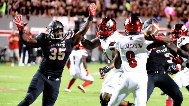 Oct 5, 2017; Raleigh, NC, USA; Louisville Cardinals quarterback Lamar Jackson (8) throws the ball as North Carolina State Wolfpack defensive end Kentavius Street (35) pressures during the first half at Carter-Finley Stadium. Photo Credit: Rob Kinnan-USA TODAY Sports