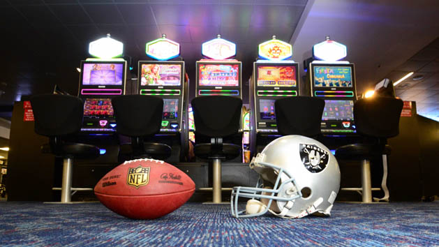 May 11, 2016; Las Vegas, NV, USA; General view of Oakland Raiders helmet and and NFL Wilson Duke football and slot machines at the McCarran International Airport. Raiders owner Mark Davis (not pictured) has pledged $500 million toward building a 65,000-seat domed stadium in Las Vegas at a total cost of $1.4 billion. Photo Credit: Kirby Lee-USA TODAY Sports